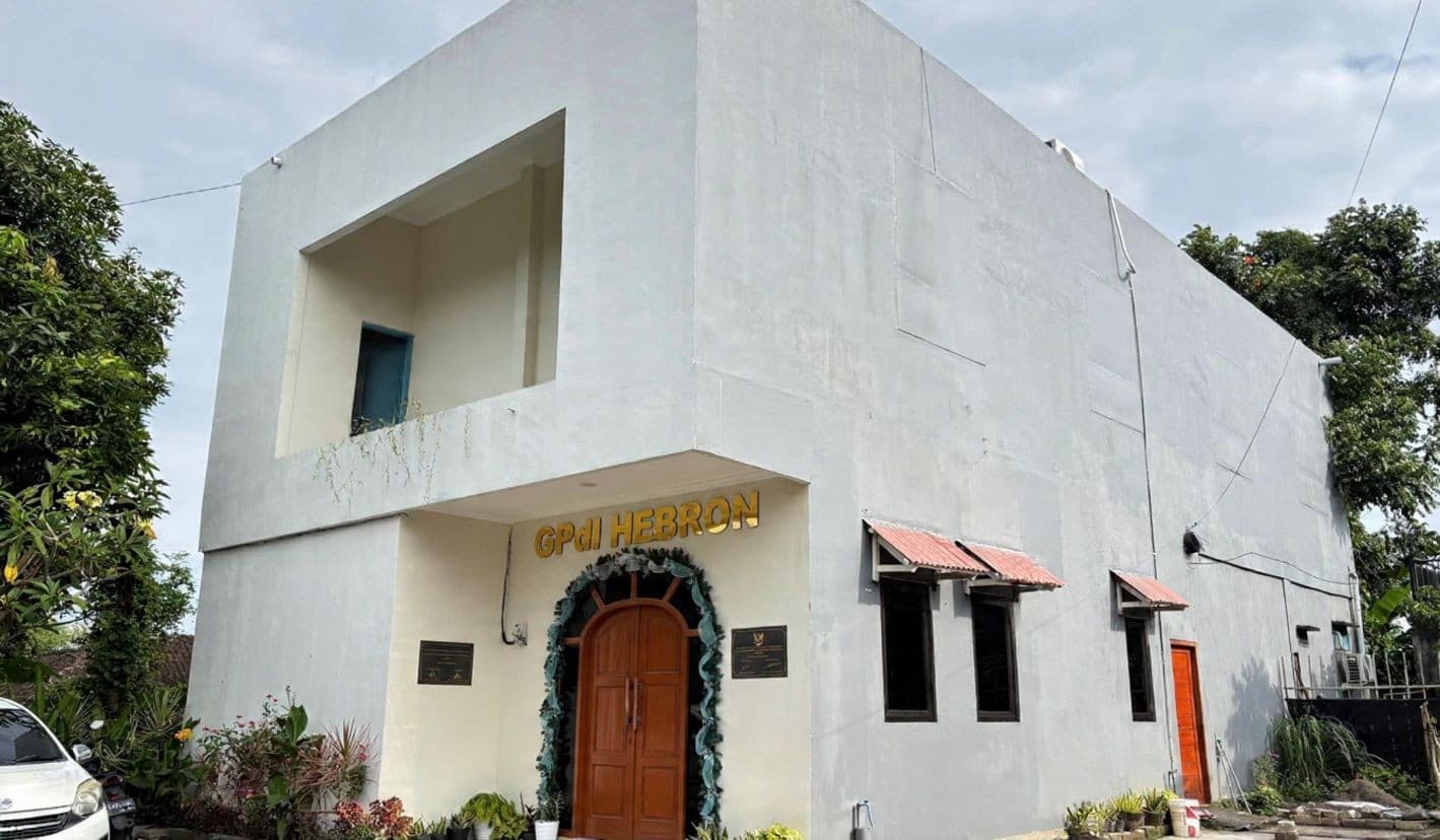 Gedung GPdI Hebron dengan tulisan emas di atas pintu kayu